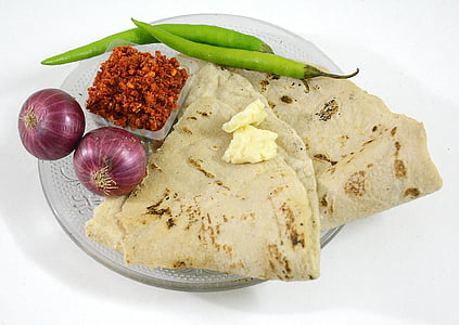 flatbread, onion bulbs, and green chili placed on plate thumbnail
