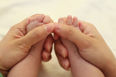 person hand holding baby's feet thumbnail