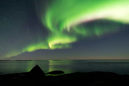 landscape photography of green aurora borealis above body of water at night time thumbnail
