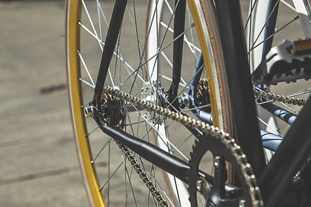 selective focus photography of black bicycle wheel on concrete pavement thumbnail