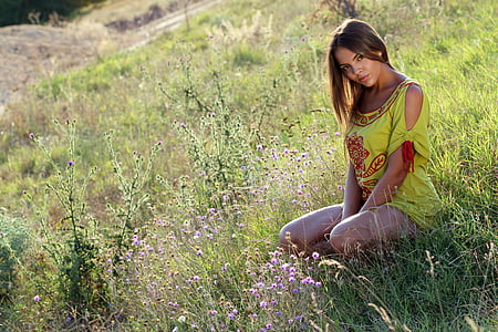 woman sitting on grass during daytime thumbnail
