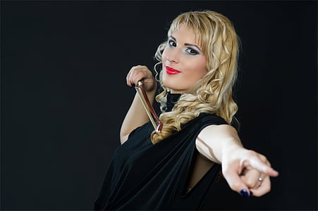 woman pointing her left hand while holding violin bow thumbnail
