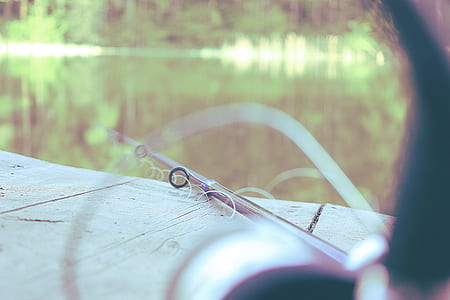 close-up photography of fishing rod beside body of water thumbnail