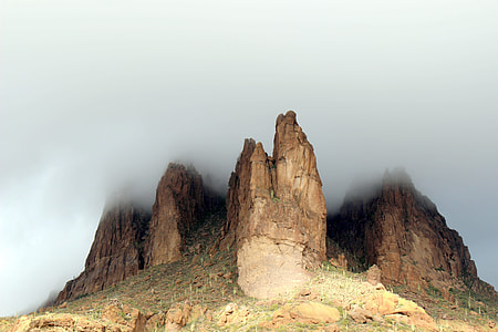 brown rock formation under cloudy sky thumbnail