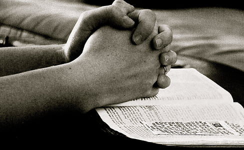 person praying hands on boook thumbnail