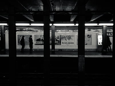 silhouette of persons walking along train statiobn thumbnail