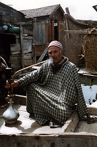 Kashmiri man smoking a traditional hookah pipe in Srinagar, Kashmir, India thumbnail