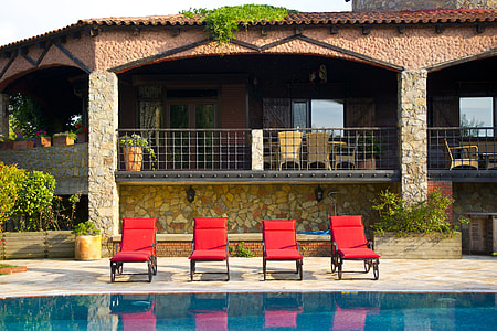four red loungers beside swimming pool thumbnail