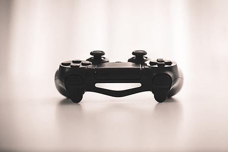 selective focus photo of black cordless game controller on top of white surface thumbnail