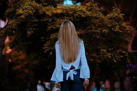 woman wearing white dress shirt facing at trees thumbnail