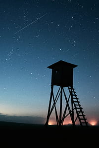 shooting star in starry night over silhouette of high-rise building thumbnail