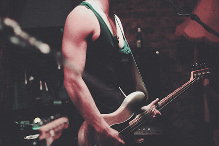 man holding guitar inside dim room thumbnail