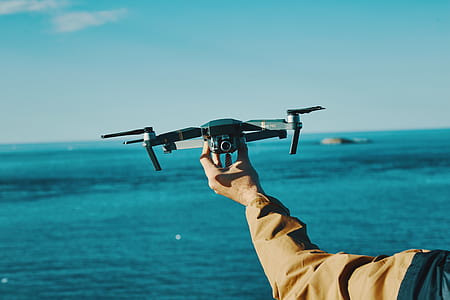 person holding black camera drone thumbnail