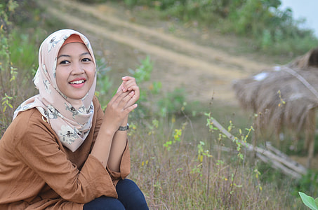 smiling woman sitting on field thumbnail