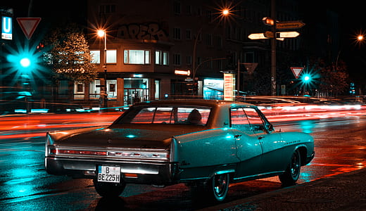 classic gray sedan running on road at nighttime thumbnail