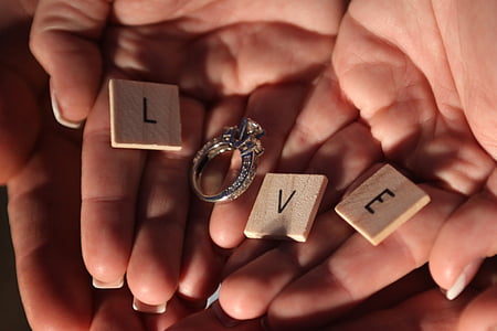 letter L, V, and E scrabble tile and silver-colored diamond stud ring to form a Love word thumbnail