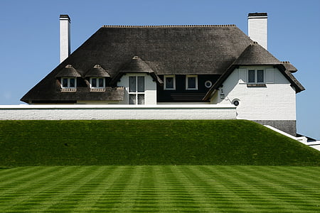 white and gray house with trimmed lawn thumbnail