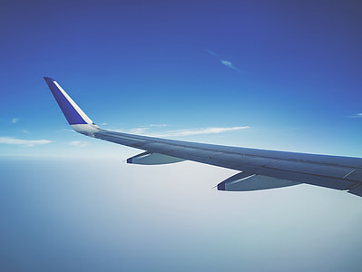 white and blue airplane wing in flight thumbnail