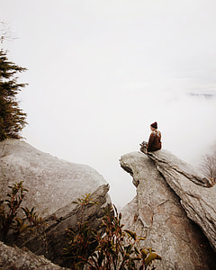 woman sitting on cliff near trees thumbnail