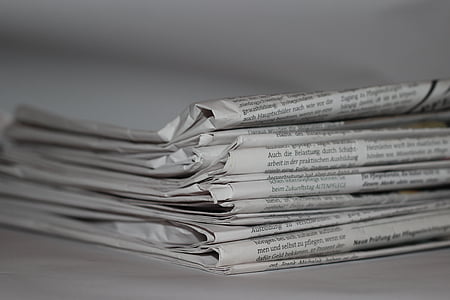 tilt shift photography of piled newspapers thumbnail
