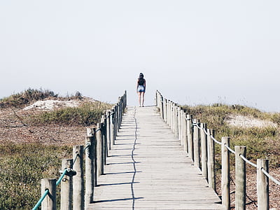 woman walking on wooden pathway thumbnail