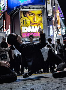 man dancing in the middle of street during daytime thumbnail