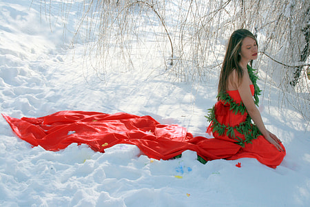 woman in red and green dress sitting on snowfield thumbnail