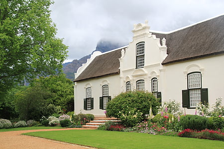 white and brown concrete house surrounded by plants thumbnail