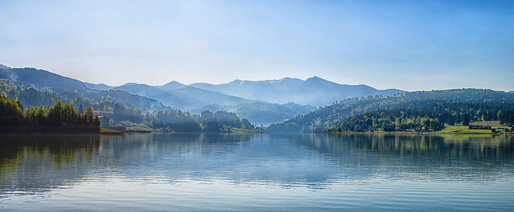 Body of Water Next to Mountain during Day Time thumbnail