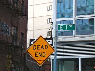 yellow Dead End road signage near brown building during daytime thumbnail