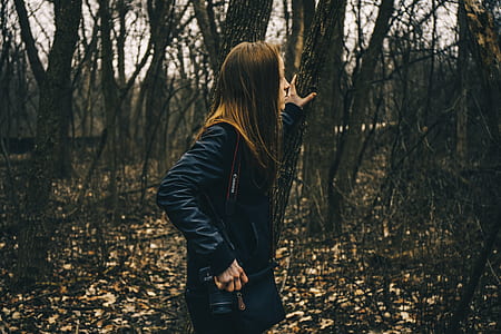 woman holding tree branch while looking the surrounding thumbnail