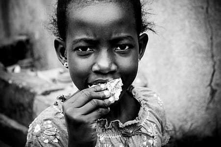 grayscale photo of girl eating food thumbnail