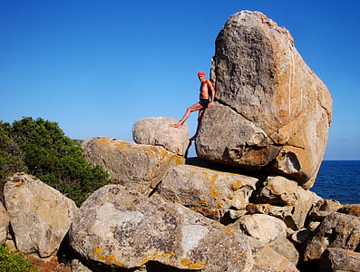 man leaning on big rock thumbnail
