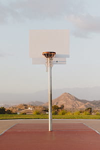 white and brown basketball system on brown court surrounded with green plants at daytime thumbnail