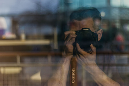 man holding Canon DSLR camera thumbnail