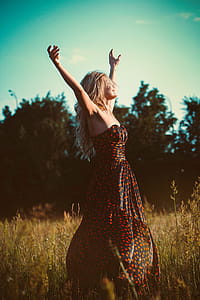 Lady in Dress Posing for Photo in Strapless Black Red Dotted Maxi Dress in Field thumbnail