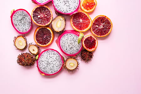 flat lane photography of sliced pomegranate, rambutan and dragon fruit thumbnail