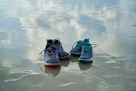 two pairs of assorted running shoes on floor thumbnail