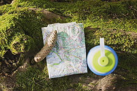 white map beside green and blue plastic container on green grass thumbnail