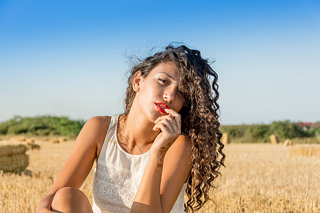 woman wearing white sleeveless shirt near brown field during daytime thumbnail