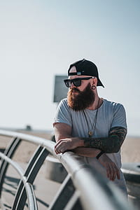 man standing beside metal fence thumbnail