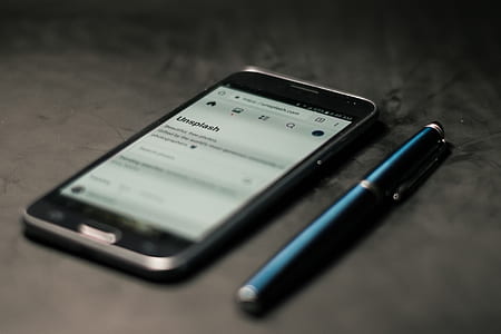 black Samsung smartphone on brown surface thumbnail