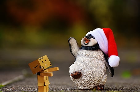 cardboard man and penguin figurine on road thumbnail
