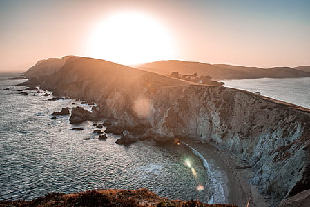 bird's-eye view photography of ocean waves hammering rock formation thumbnail