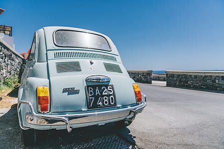 white vehicle parked beside road at daytime thumbnail