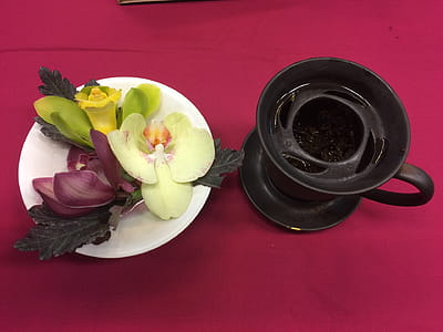 assorted-color petaled flowers on plate beside black coffee cup thumbnail
