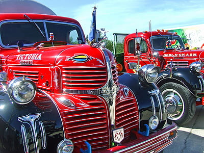 two red Dodge Victoria and Noble Charm trucks under blue sky during daytime thumbnail