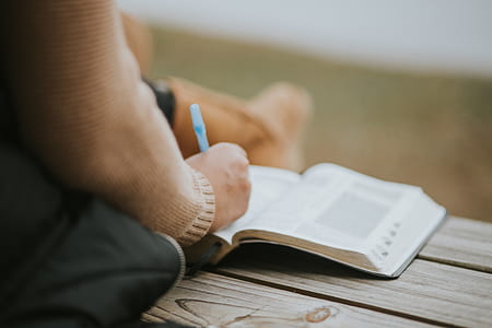 person writing on book thumbnail