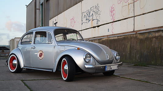 parked gray Volkswagen Beetle on gray pavement thumbnail