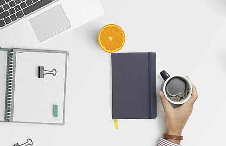 Overhead shot of desk space with coffee, computer, notebooks. thumbnail